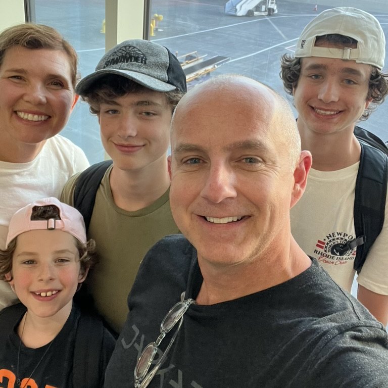 The founder of VNAV Flight Labs with his family at an airport terminal window